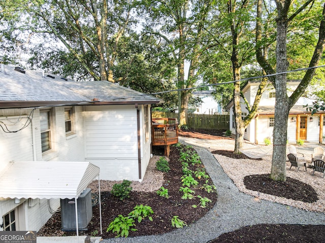 view of yard featuring central air condition unit and a wooden deck