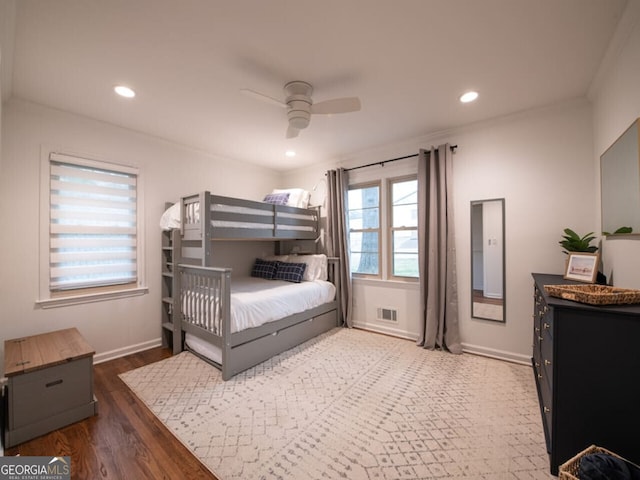 bedroom featuring dark hardwood / wood-style floors, ceiling fan, and ornamental molding