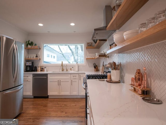 kitchen featuring white cabinets, stainless steel appliances, light stone counters, and sink