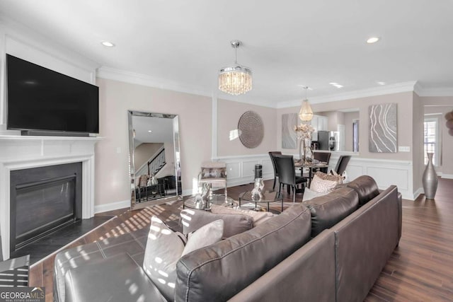 living room featuring a chandelier, dark hardwood / wood-style flooring, and crown molding