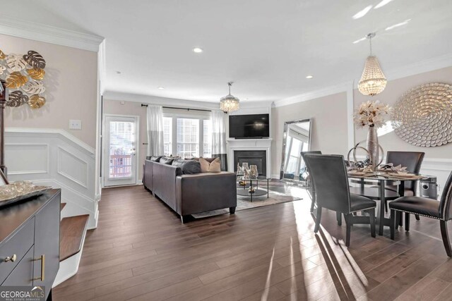 living room featuring dark hardwood / wood-style flooring, a chandelier, and ornamental molding