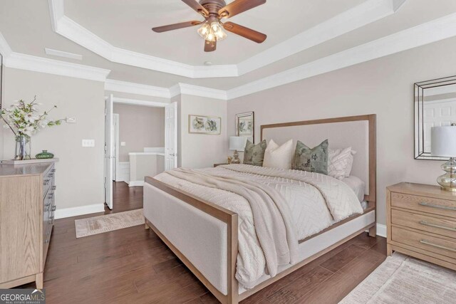 bedroom with a tray ceiling, ceiling fan, and dark wood-type flooring