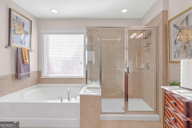 bathroom with plus walk in shower, tile patterned flooring, and vanity