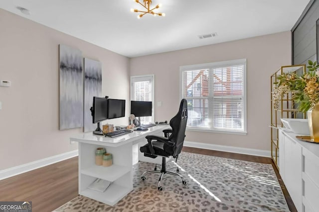 office space featuring dark wood-type flooring and a chandelier