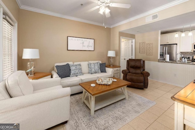 living room featuring sink, ceiling fan, ornamental molding, and light tile patterned flooring