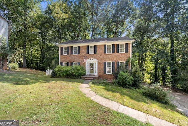 colonial-style house featuring a front lawn