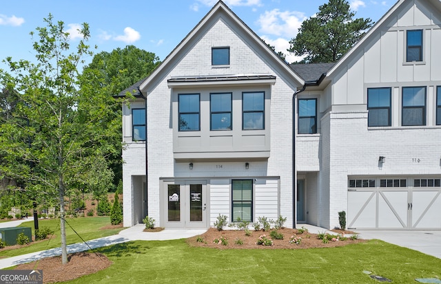 view of front of home with french doors, a front lawn, and a garage