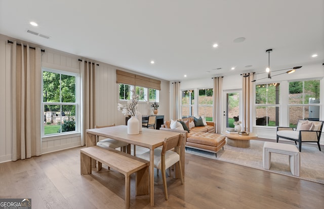 dining space with an inviting chandelier, light hardwood / wood-style flooring, and a wealth of natural light