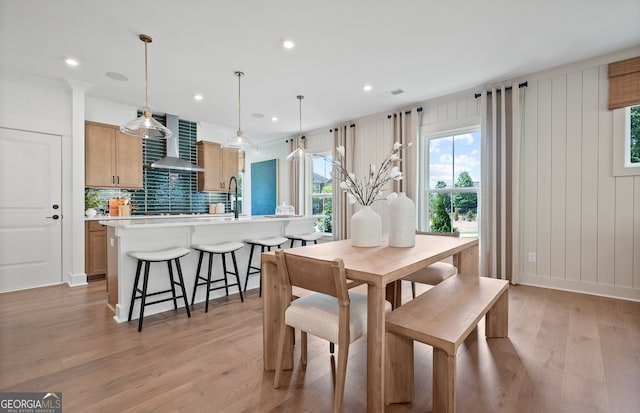 dining area featuring crown molding, plenty of natural light, and light hardwood / wood-style floors