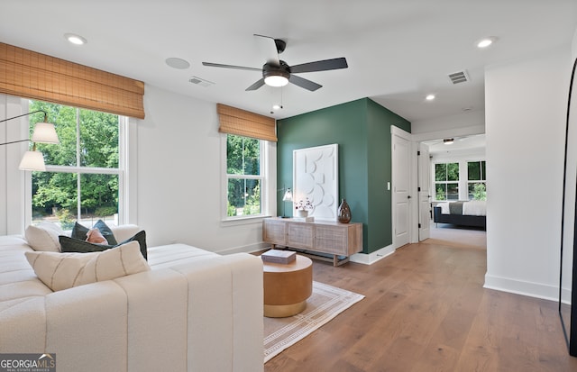 living room featuring a wealth of natural light, ceiling fan, and wood-type flooring