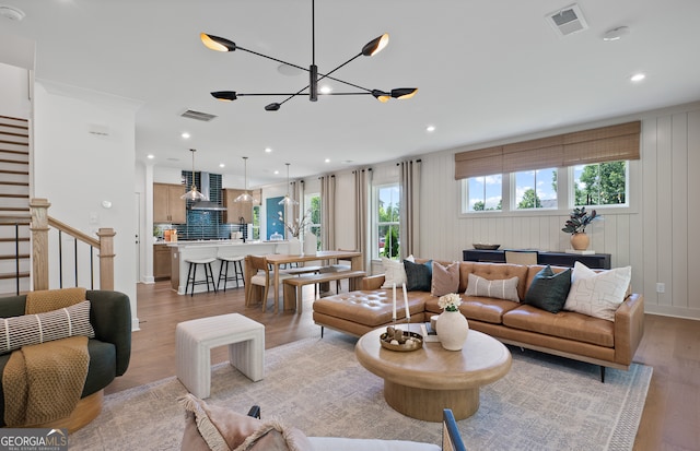 living room featuring light hardwood / wood-style flooring and an inviting chandelier