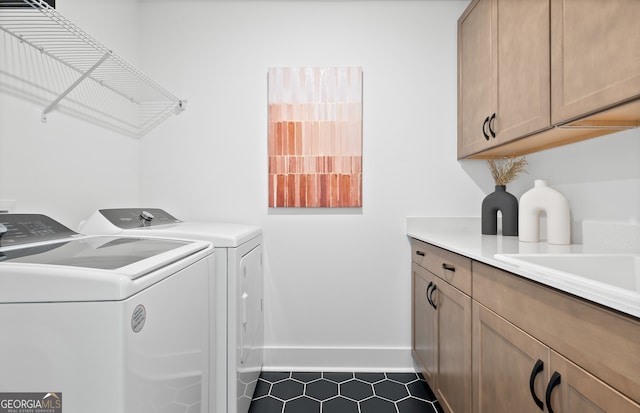 laundry area with washer and clothes dryer, cabinets, and dark tile patterned flooring