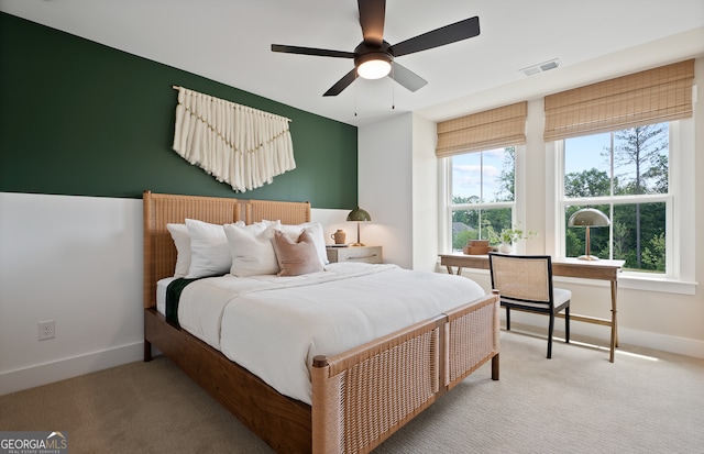 carpeted bedroom with multiple windows and ceiling fan