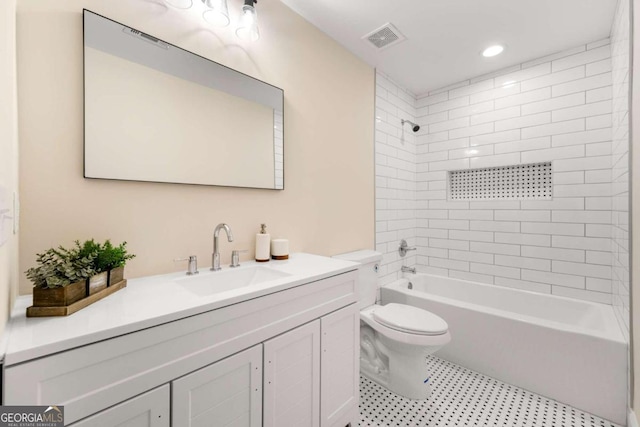 full bathroom with vanity, tiled shower / bath combo, and toilet