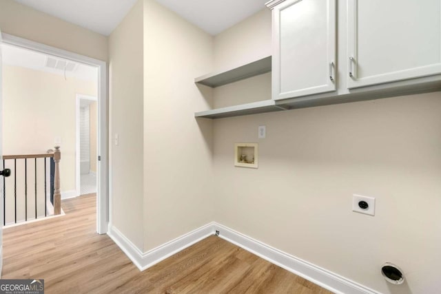 laundry area with cabinets, hookup for a washing machine, light hardwood / wood-style flooring, and hookup for an electric dryer