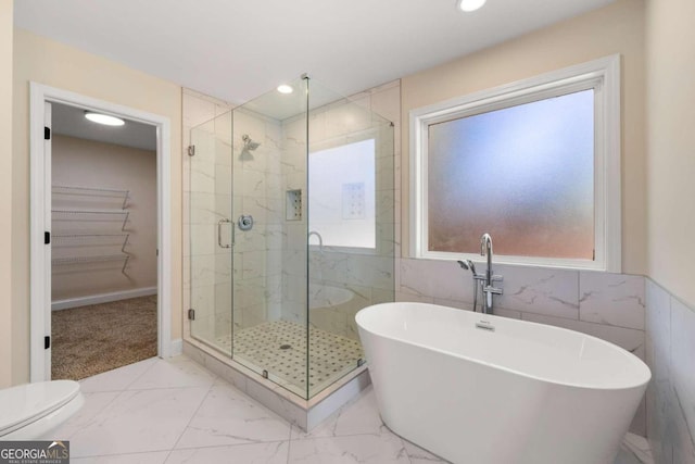 bathroom with separate shower and tub and tile walls