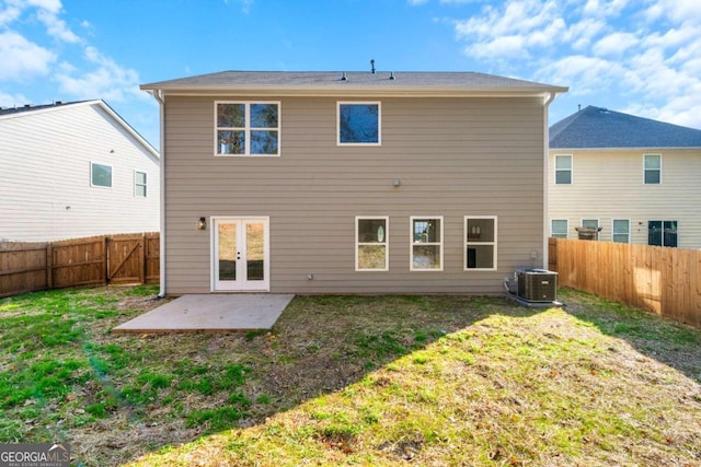 back of property with a yard, a patio, and central AC