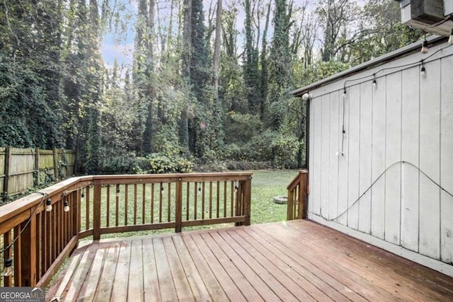 wooden deck featuring a lawn