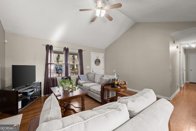 living room featuring hardwood / wood-style floors, ceiling fan, and lofted ceiling