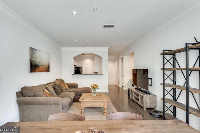 living room with hardwood / wood-style flooring, ornamental molding, and a textured ceiling