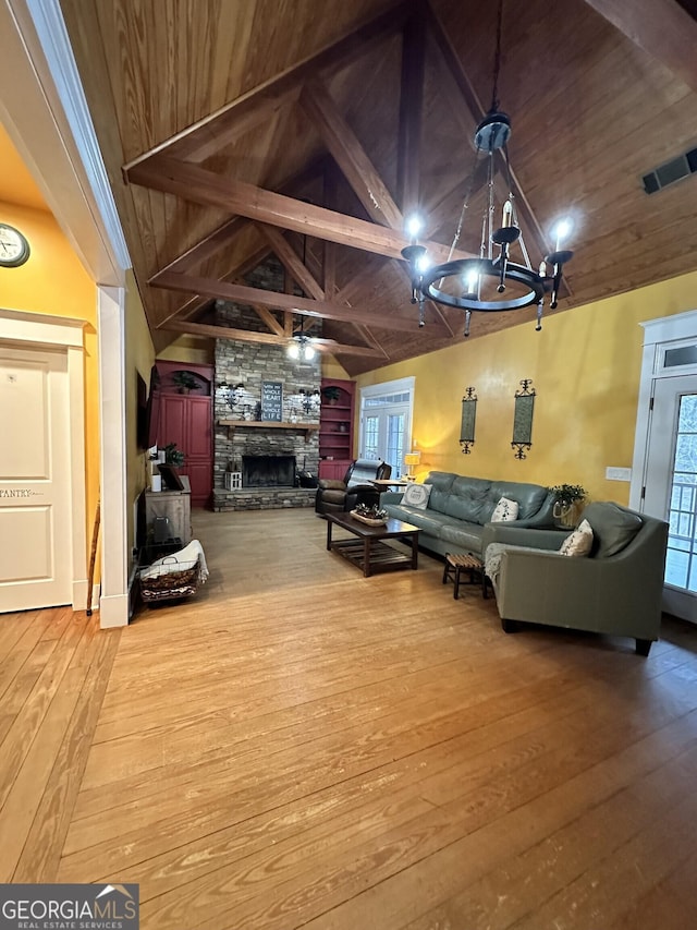 living room featuring wooden ceiling, beamed ceiling, high vaulted ceiling, hardwood / wood-style floors, and a fireplace