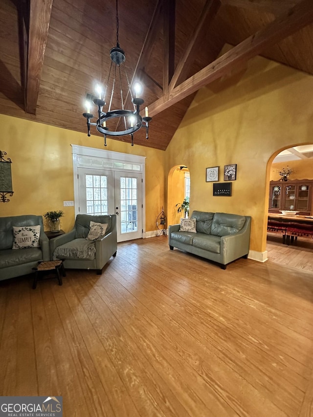 living room featuring wood-type flooring, high vaulted ceiling, wooden ceiling, beamed ceiling, and a chandelier