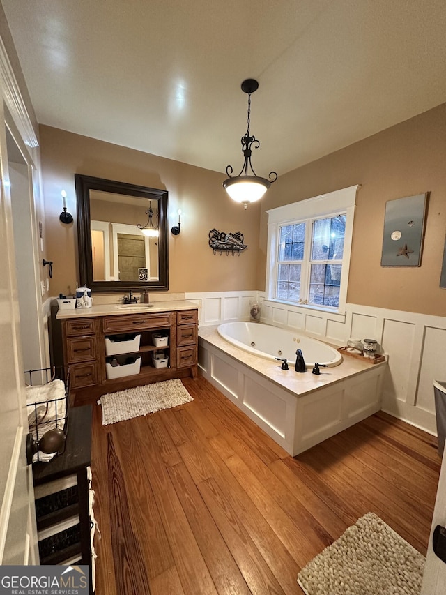 bathroom with a bathing tub, vanity, and wood-type flooring