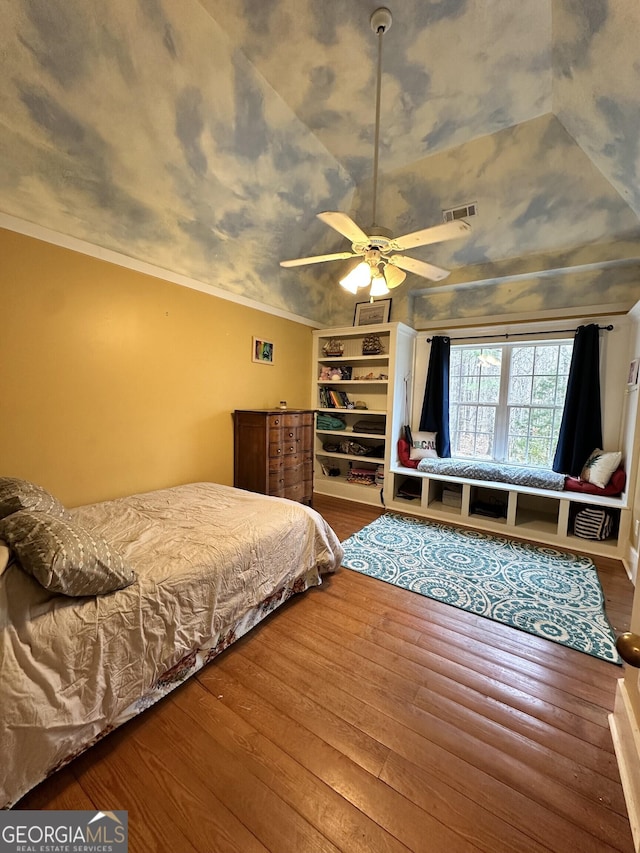 bedroom with hardwood / wood-style flooring, ceiling fan, and ornamental molding