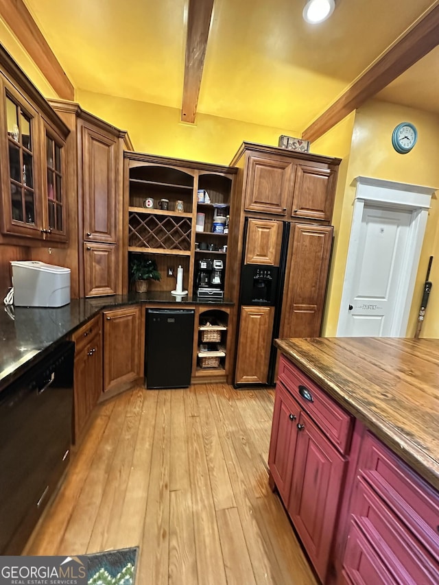 kitchen with beam ceiling, dishwasher, dark stone countertops, fridge, and light wood-type flooring