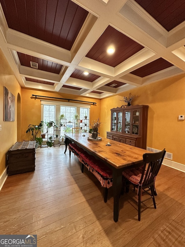 dining room with crown molding, light hardwood / wood-style flooring, beamed ceiling, and coffered ceiling