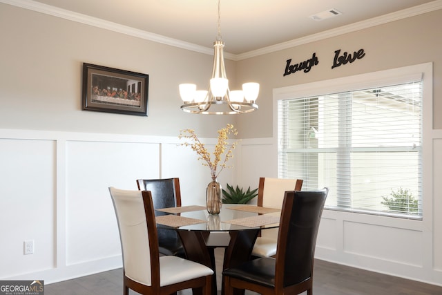 dining space with dark hardwood / wood-style floors, ornamental molding, and a chandelier