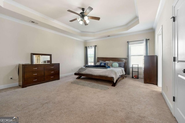 carpeted bedroom featuring a raised ceiling, ceiling fan, and ornamental molding