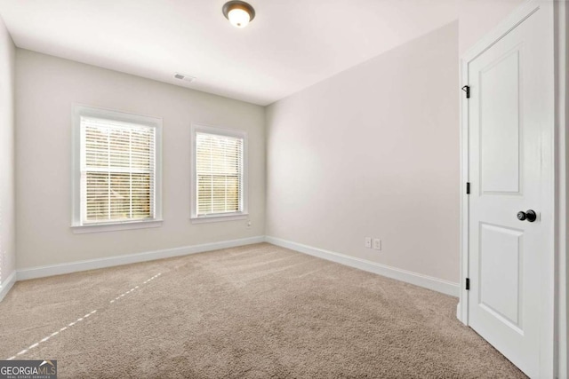 spare room featuring light colored carpet