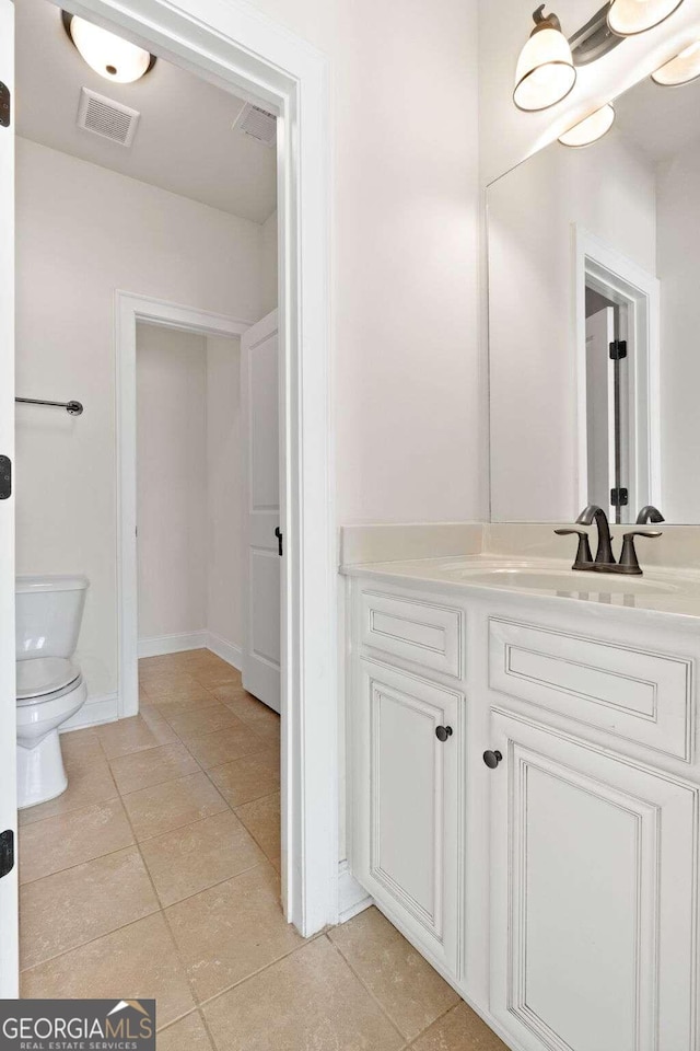 bathroom featuring toilet, vanity, and tile patterned floors