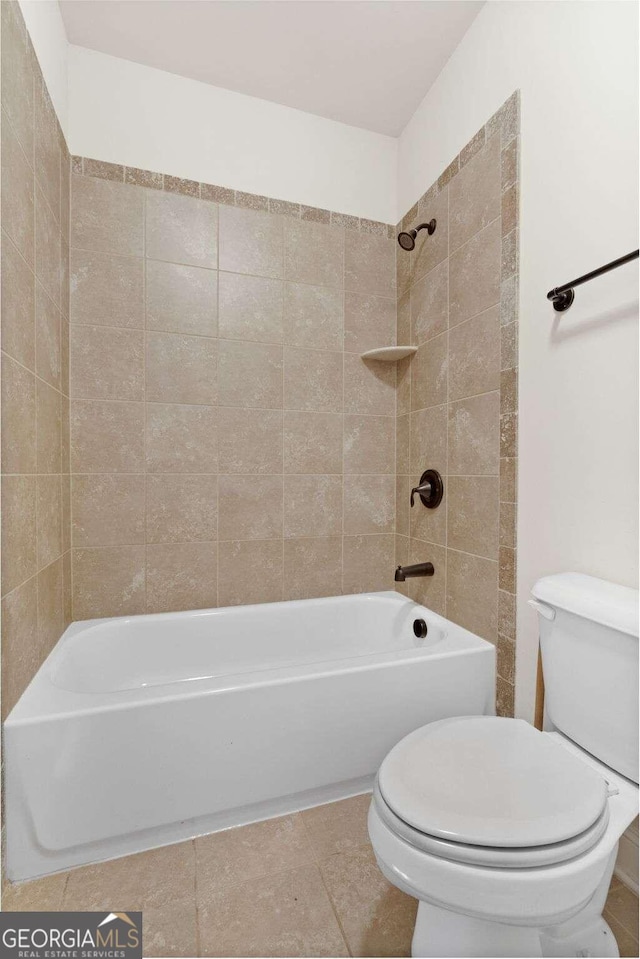 bathroom featuring tile patterned floors, tiled shower / bath combo, and toilet