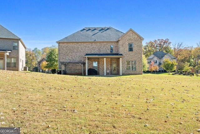 rear view of property with central AC unit and a yard