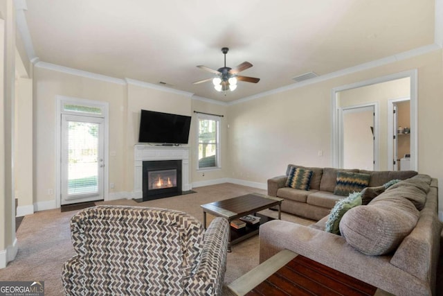 carpeted living room featuring ornamental molding, ceiling fan, and a healthy amount of sunlight