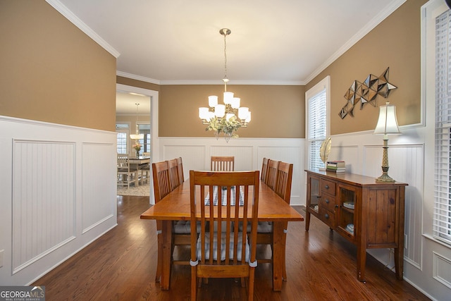 dining space featuring ornamental molding, plenty of natural light, and an inviting chandelier