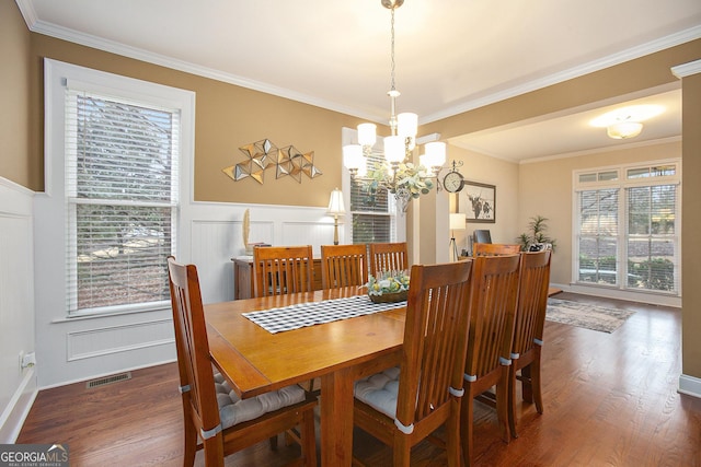 dining area with crown molding, plenty of natural light, a chandelier, and dark wood-type flooring