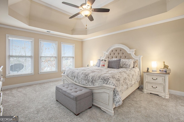 carpeted bedroom featuring a tray ceiling, ornamental molding, and ceiling fan