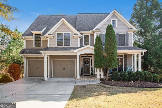 view of front of home featuring a front yard, a porch, and a garage