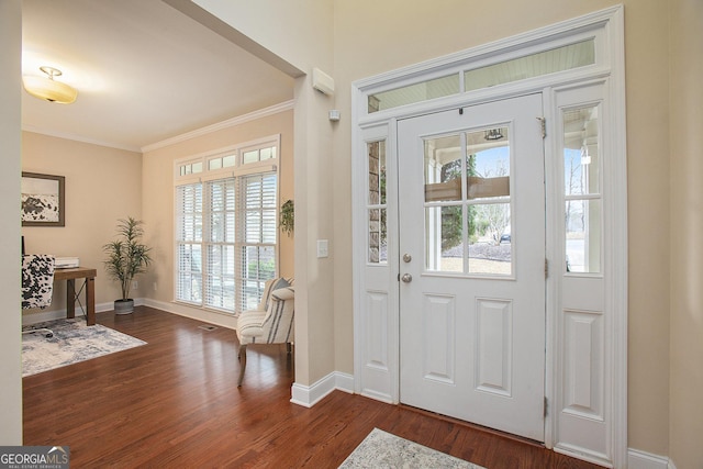 foyer entrance with crown molding and dark hardwood / wood-style flooring