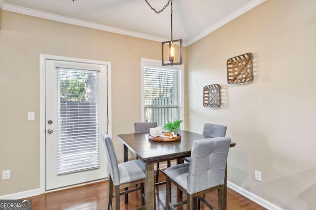 dining area with hardwood / wood-style floors and crown molding