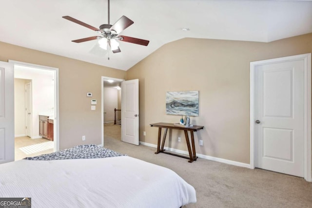 bedroom featuring connected bathroom, light colored carpet, vaulted ceiling, and ceiling fan