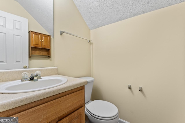 half bath featuring a textured ceiling, vanity, toilet, and lofted ceiling