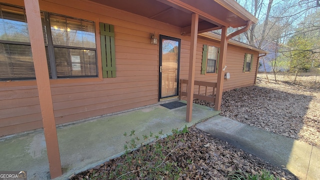 view of exterior entry with a patio