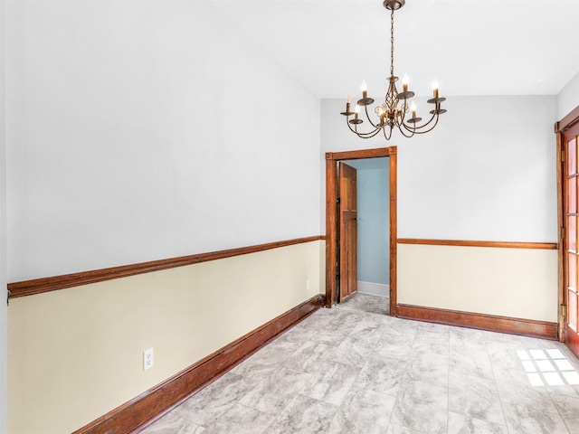 empty room with a chandelier and vaulted ceiling