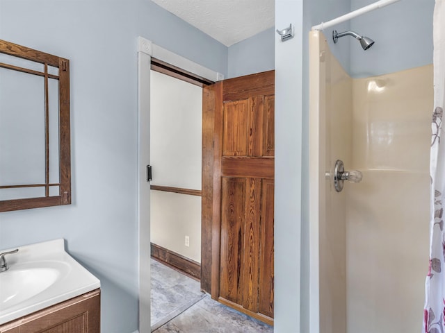 bathroom featuring tile patterned flooring, vanity, a textured ceiling, and a shower with shower curtain