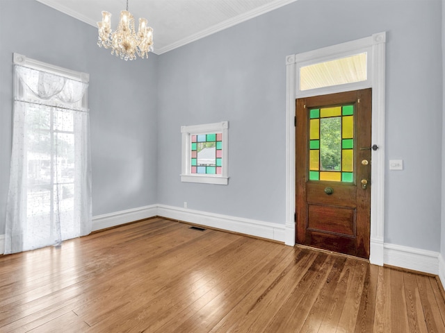 entryway with hardwood / wood-style flooring, a notable chandelier, and ornamental molding