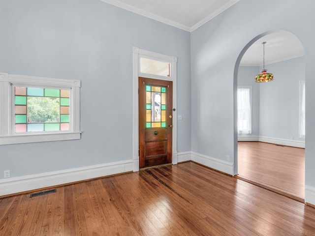 entryway with wood-type flooring and ornamental molding